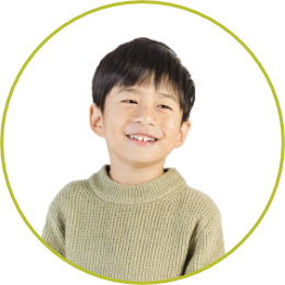 photo of a boy smiling wearing a green sweater