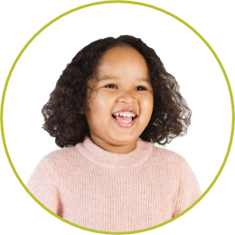 Photo of a preschool girl smiling wearing pink sweater