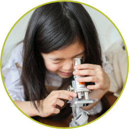 photo of a girl looking into a microscope